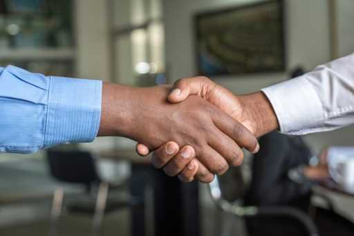 Deux personnes se serrant la main symbolisant la résolution d’un conflit et le rétablissement du dialogue