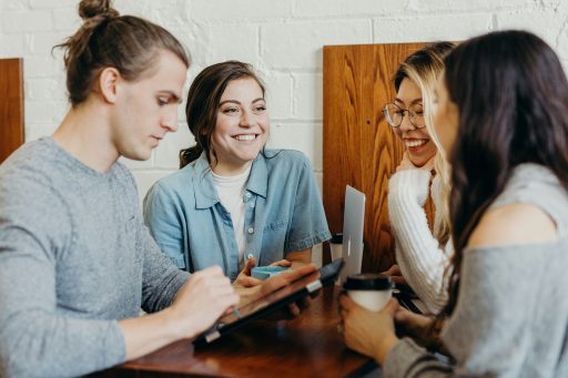 Groupe de collaborateurs échangeant autour d’une table dans un moment de discussion conviviale